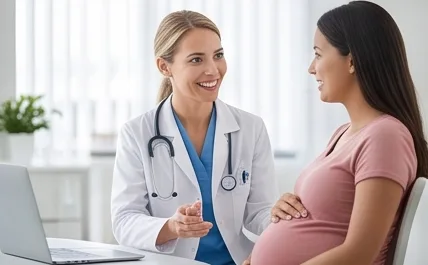A doctor talking with a smiling pregnant woman in a consultation room